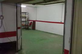 Large closed garage space with storage room and natural light.